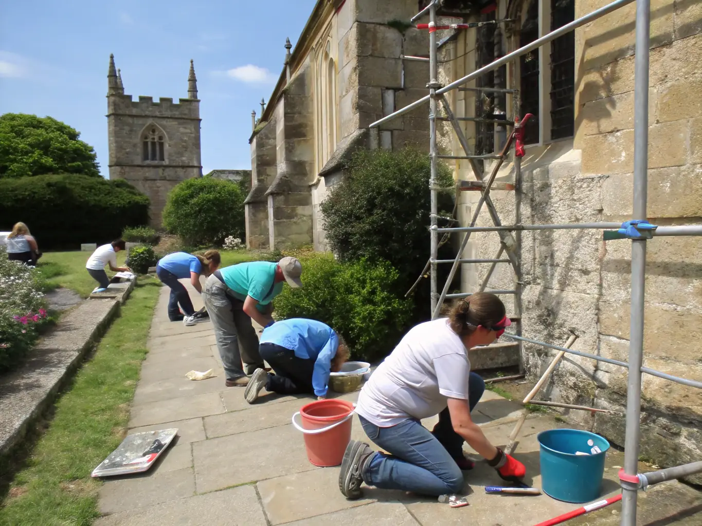 A group of volunteers working together to restore a section of the tidal mill, focusing on repairing stonework and reinforcing the structure.